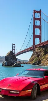 Red car parked by Golden Gate Bridge under clear blue sky.