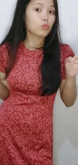 Woman in red patterned dress showing peace signs.