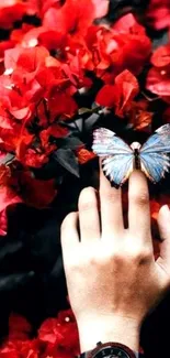 Hand with butterfly amid red flowers, featuring a wristwatch.