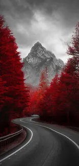 Winding road through a vibrant red forest leading to a majestic mountain.