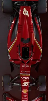 Top view of a red Formula 1 car on a textured background.