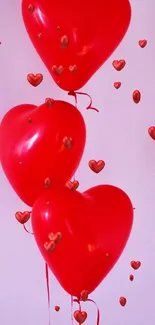 Three red heart-shaped balloons floating against a soft pink background.