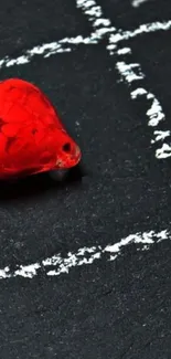 Red heart on blackboard with chalk lines art.