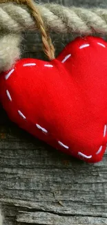 Red fabric heart on rustic rope background, mobile wallpaper.