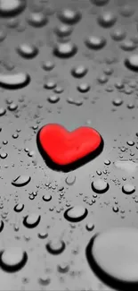 Red heart on wet black surface with water droplets shining.