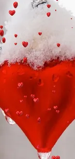 Snow-covered red heart ornament with icicles on a wintery background.