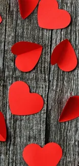 Red paper hearts on rustic wood background, mobile wallpaper.