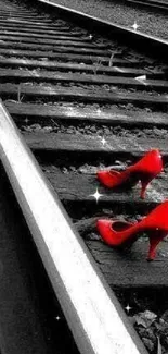 Red high heels on a monochrome railway track.