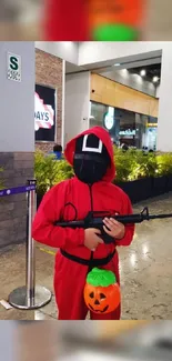 Masked individual in red hood inside shopping center.