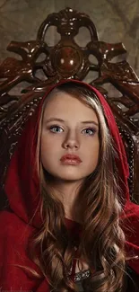 Mysterious girl in red hooded cape seated on ornate chair.