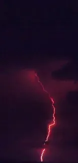 Vibrant red lightning striking through dark night sky.