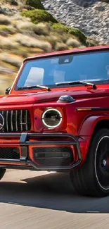 Red luxury SUV on a scenic mountain road.