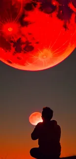 Silhouette under a large glowing red moon in the night sky.