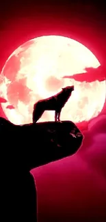 Silhouette of a wolf against a bright red full moon.