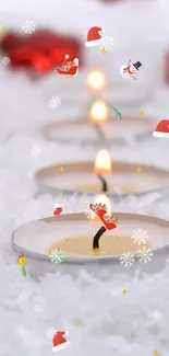 Red Christmas ornaments with candles on snow.