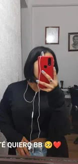 Mirror selfie featuring red phone case and casual black outfit.