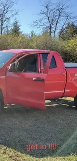 Red pickup truck with open door in nature scene.