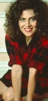 Woman with curly hair in red plaid on vintage wallpaper.