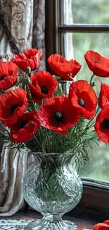 Red poppies in a vase by a window.