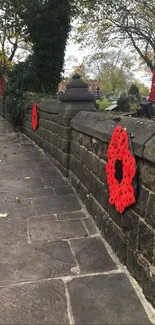 Stone path with red poppy flowers on the walls, under a canopy of trees.