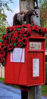 Red postbox adorned with yarn art and knitted decorations.