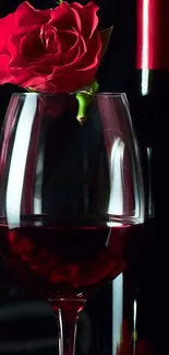 Red rose resting on a wine glass, set against a dark background.