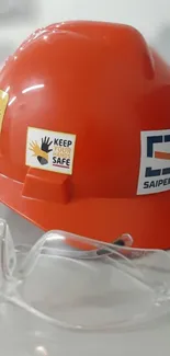 Red safety helmet and goggles on display.