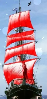 Ship with red sails against a bright blue sky and ocean backdrop.