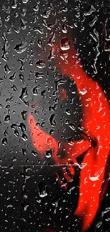 Red silhouette behind rain-streaked glass, artistic mobile wallpaper.