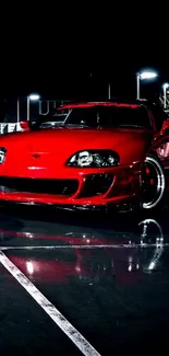 Sleek red sports car under night lights.