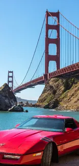 Red sports car in front of Golden Gate Bridge, clear blue sky.