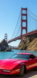 Red sports car near Golden Gate Bridge in sunny weather.