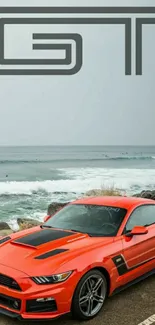 Red sports car parked by the ocean with scenic GT logo backdrop.