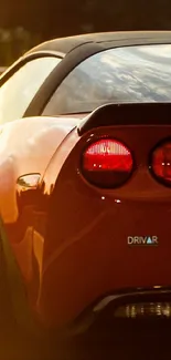 Red sports car driving at sunrise on a highway, showcasing speed and adventure.