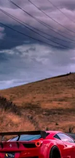 Red sports car on a winding road with dramatic sky background.