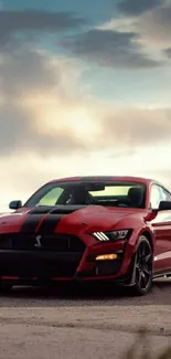 Red sports car parked under a cloudy sky.