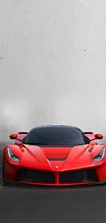 Sleek red sports car against a misty backdrop.