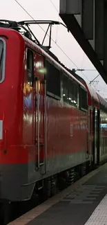 Red train parked at an urban station platform, ready for departure.