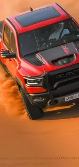 Red truck driving through desert sand dunes.