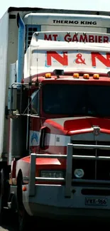 Red truck driving on a sunny highway.