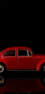 Red vintage car on black background with reflection.