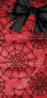 Red background with spider web designs and a black bow accent.