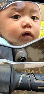 Baby's reflection in motorcycle mirror, curious gaze.