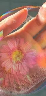 Hand holding a soap bubble with a pink flower inside.