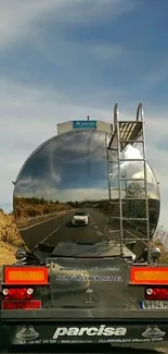 Reflective truck on highway with blue sky.