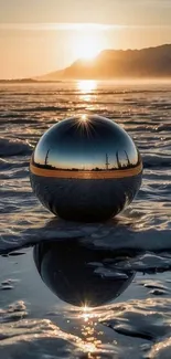 Reflective sphere on ice with sunset backdrop and mountain view.