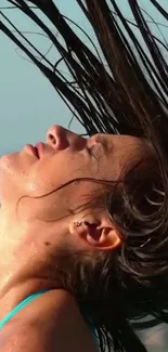 Woman enjoying beach with wind in hair.