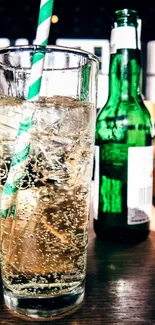 Glass of soda with green bottle in the background.