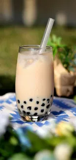 A refreshing glass of bubble tea with boba pearls on a blue and white cloth.