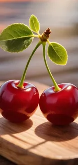 Two vibrant red cherries with green leaves on a wooden surface.